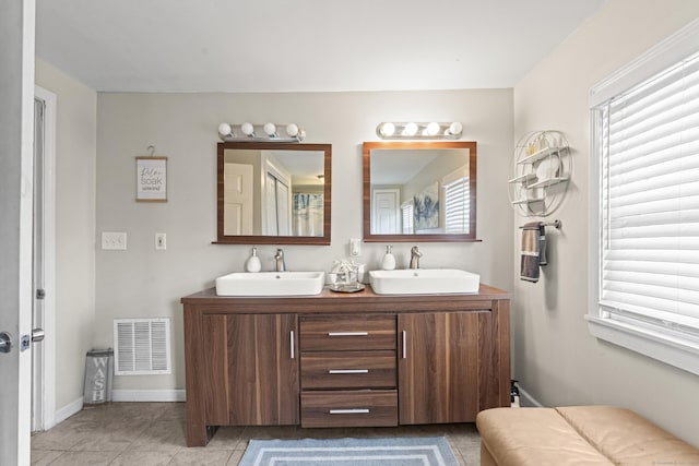bathroom featuring double vanity, visible vents, a sink, and tile patterned floors