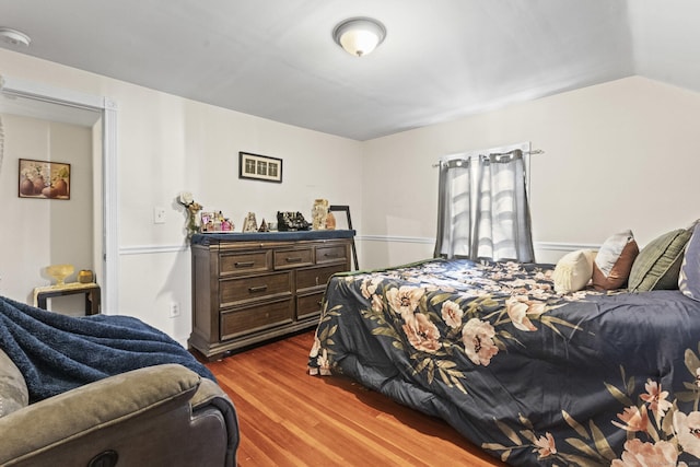 bedroom with lofted ceiling and wood finished floors