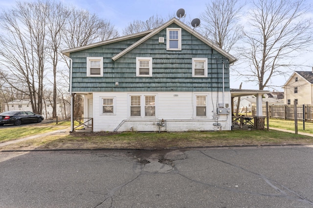 view of property exterior with a lawn and fence