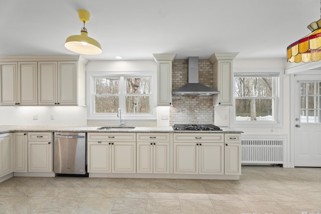 kitchen featuring cream cabinets, wall chimney exhaust hood, radiator, dishwasher, and a sink