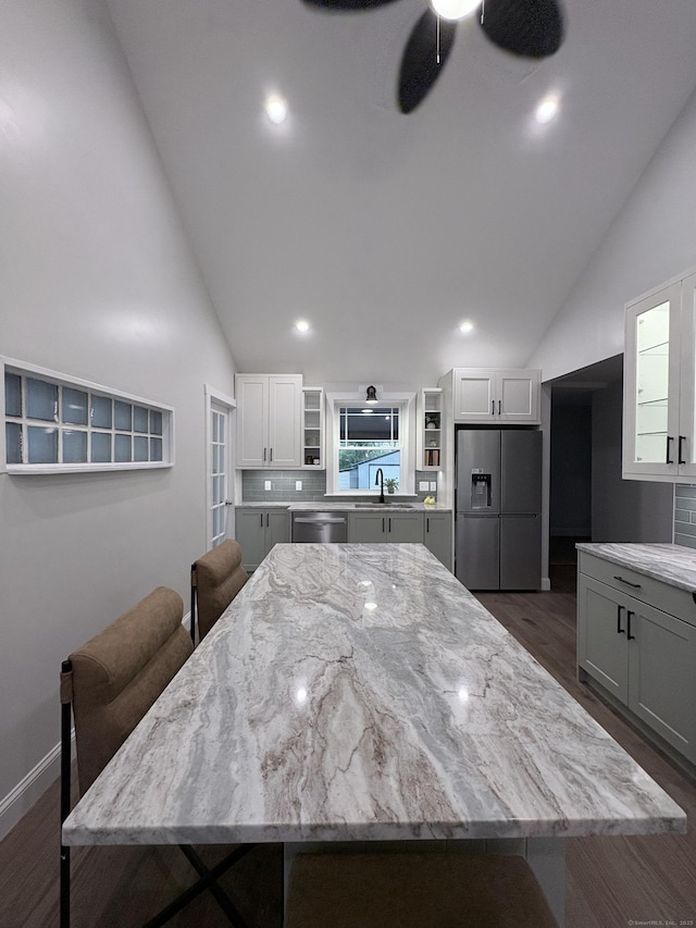 220 W Rd, Colchester, CT 06415 - kitchen with stainless steel appliances, open shelves, light stone countertops, ceiling fan, and high vaulted ceiling