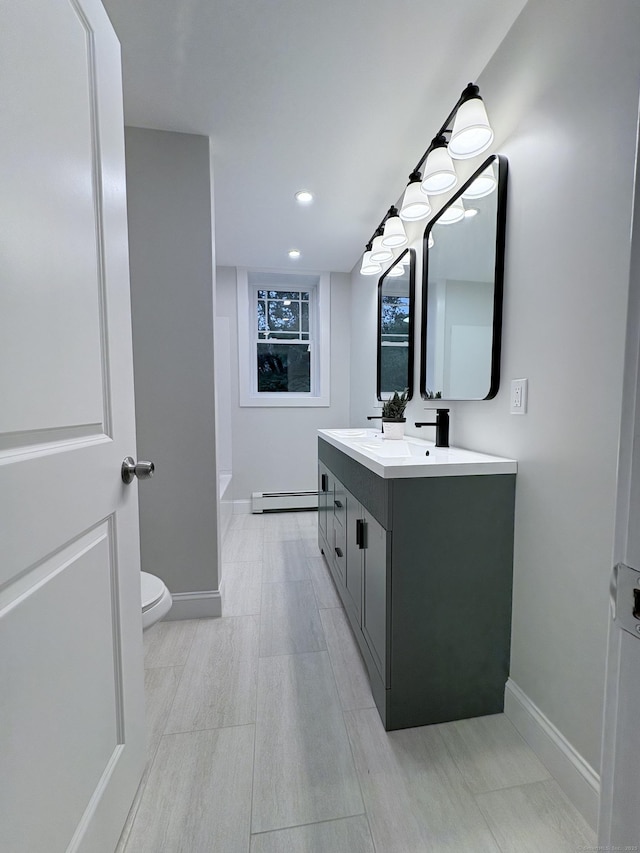 220 W Rd, Colchester, CT 06415 - bathroom featuring a baseboard heating unit, baseboards, double vanity, toilet, and recessed lighting