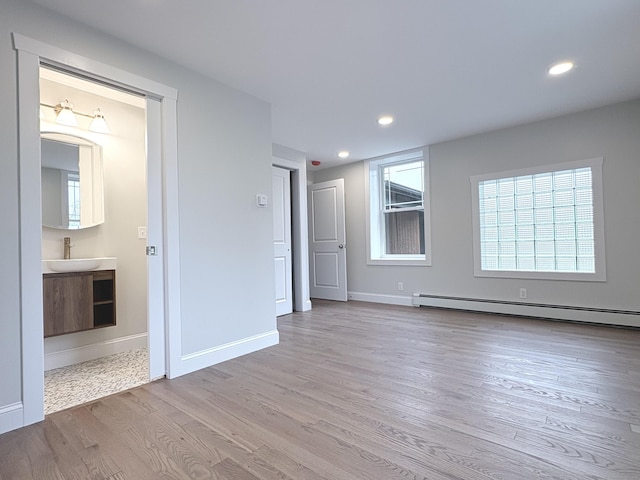 220 W Rd, Colchester, CT 06415 - spare room featuring a baseboard heating unit, wood finished floors, baseboards, recessed lighting, and a sink