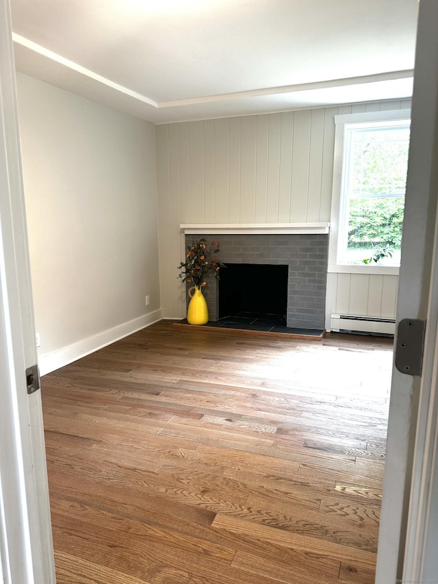 220 W Rd, Colchester, CT 06415 - unfurnished living room featuring a baseboard heating unit, a fireplace, wood finished floors, and baseboards