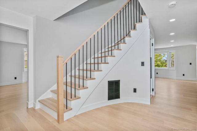 stairway featuring wood finished floors, baseboards, and recessed lighting