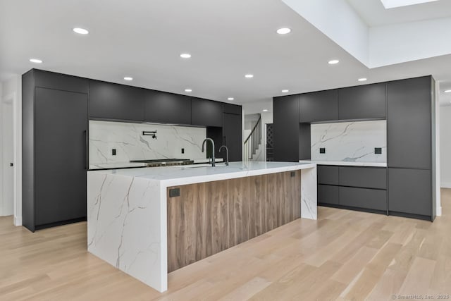 32 Pine Hill Ave, Norwalk, CT 06855 - kitchen featuring modern cabinets, dark cabinets, light wood-style floors, and recessed lighting