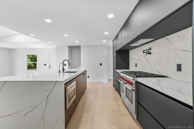 32 Pine Hill Ave, Norwalk, CT 06855 - kitchen featuring modern cabinets, a sink, decorative backsplash, recessed lighting, and light wood-style flooring