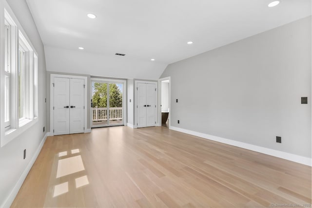 unfurnished living room with recessed lighting, light wood finished floors, baseboards, and vaulted ceiling