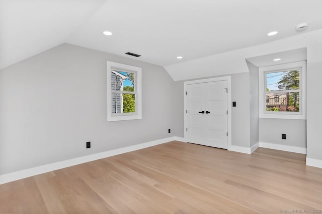 additional living space with lofted ceiling, light wood-style flooring, baseboards, and recessed lighting
