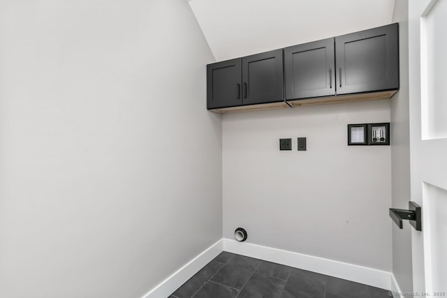 clothes washing area with baseboards and cabinet space