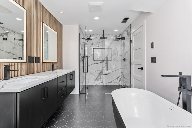bathroom featuring a marble finish shower, recessed lighting, tile patterned flooring, a freestanding tub, and double vanity