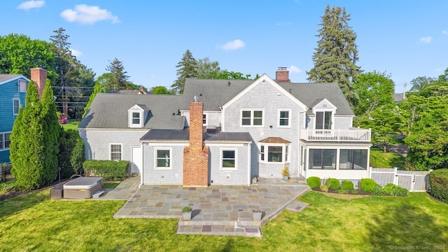 rear view of property featuring a chimney, a patio, a balcony, and a gate