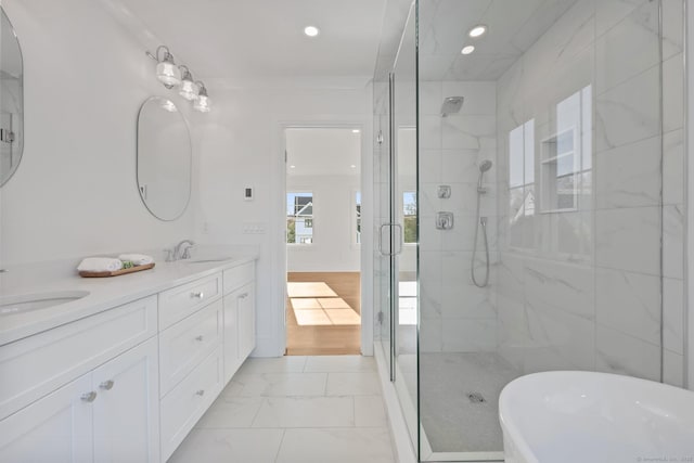 71 Reid St, Fairfield, CT 06824 - bathroom with a shower stall, double vanity, a freestanding bath, marble look tile flooring, and recessed lighting