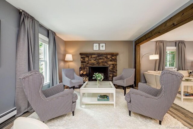 18 Tunnel Rd, Roxbury, CT 06783 - living area featuring baseboard heating, a stone fireplace, and wood finished floors
