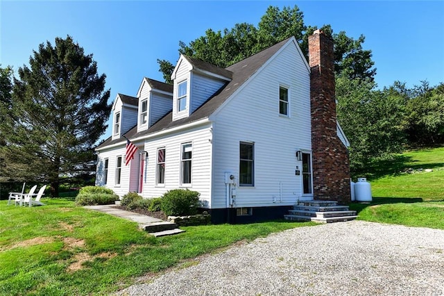 cape cod home featuring a front lawn and a chimney