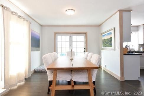 dining area with dark wood-type flooring, a wealth of natural light, and baseboards