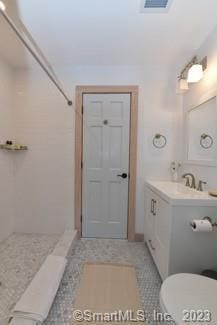 bathroom with toilet, walk in shower, vanity, and visible vents