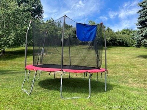 view of home's community featuring a lawn and a trampoline