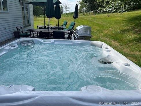 exterior space with a lawn and a hot tub