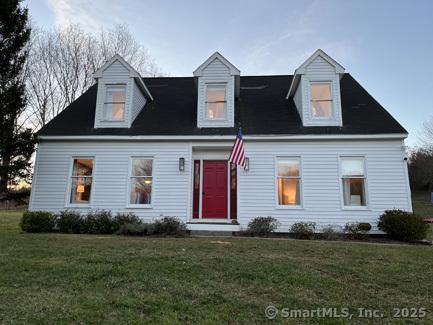 cape cod-style house with a front lawn