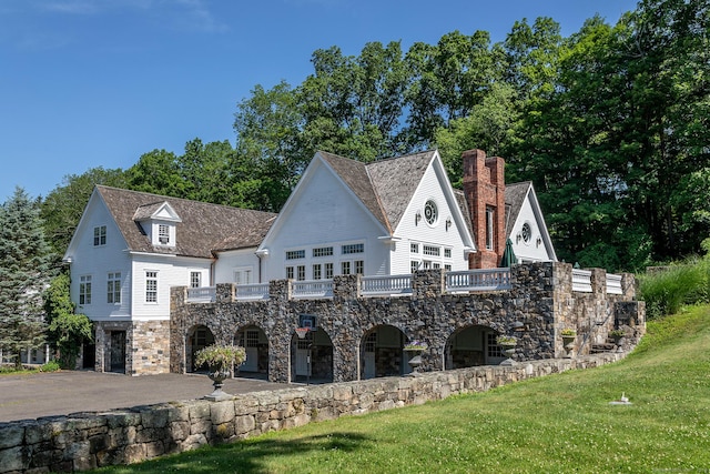 10 Sunny Ridge Rd, Washington, CT 06793 - view of front of property featuring stone siding, a front lawn, a balcony, and a chimney