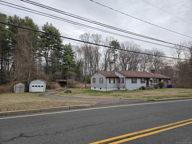 179 Spring St, Windsor Locks, CT 06096 - view of front of property featuring a front yard, driveway, a chimney, and an outbuilding