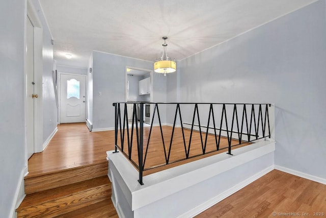 staircase featuring baseboards and wood finished floors