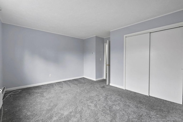 unfurnished bedroom with a closet, carpet flooring, and baseboards