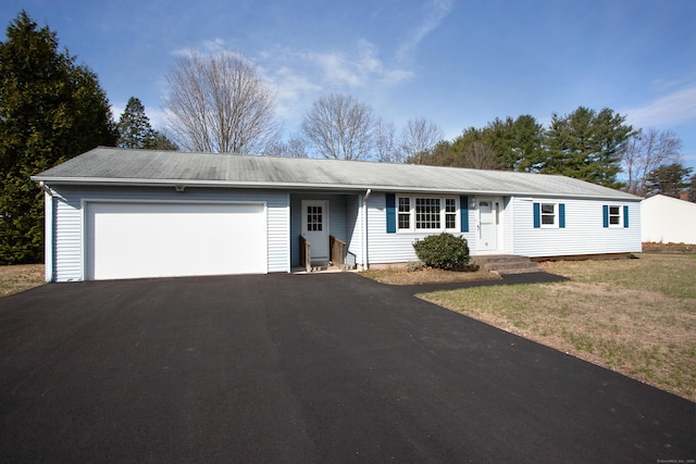 single story home with driveway, a garage, and a front lawn