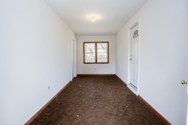 unfurnished room with baseboards