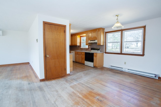 kitchen featuring a sink, tasteful backsplash, baseboard heating, range with electric stovetop, and under cabinet range hood