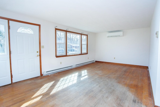 entryway with baseboards, an AC wall unit, light wood-style flooring, and a baseboard heating unit