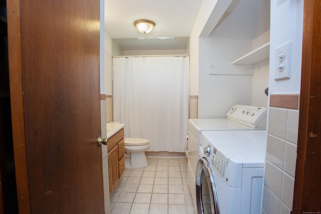 washroom featuring independent washer and dryer, light tile patterned floors, and laundry area
