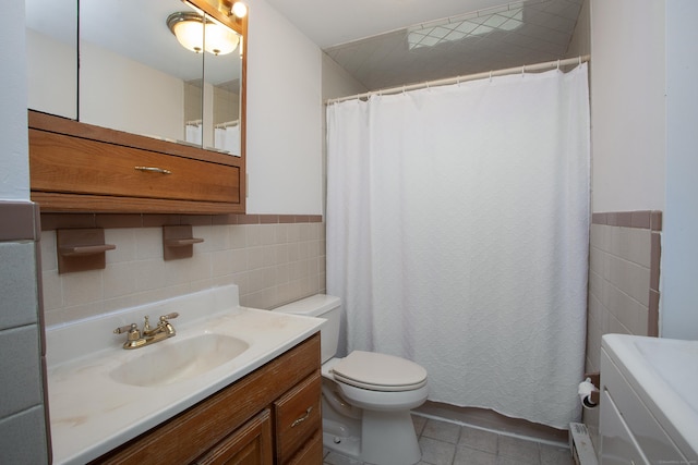 bathroom featuring tile walls, a wainscoted wall, toilet, tile patterned floors, and vanity