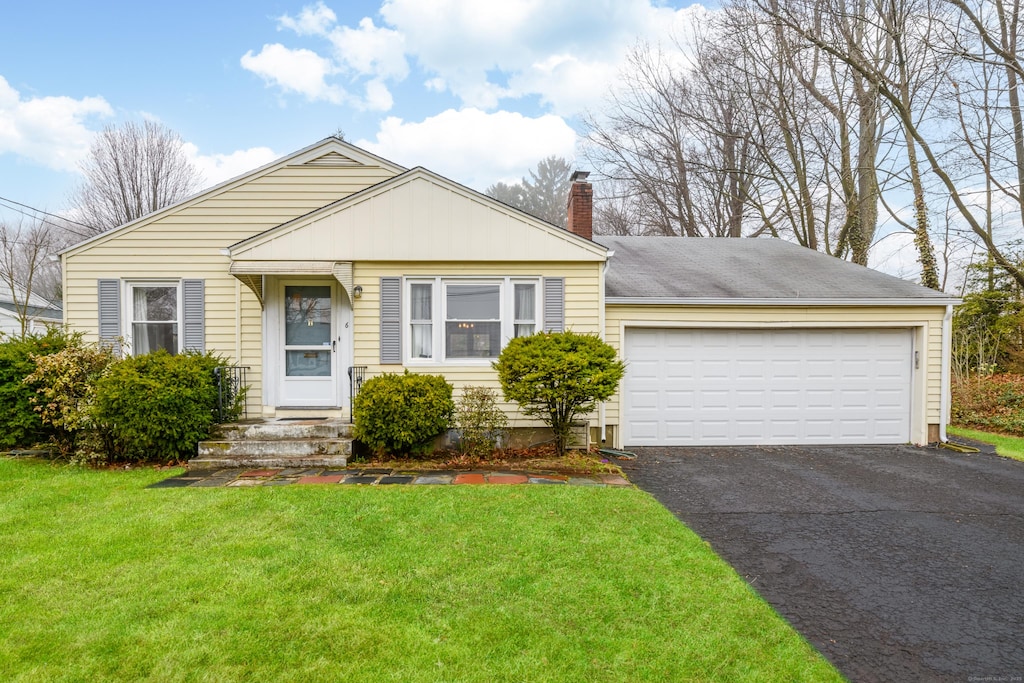 6 Hepburn Rd, Hamden, CT 06517 - view of front of house with a front lawn, a chimney, an attached garage, and aphalt driveway