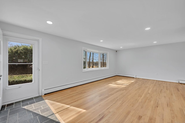 empty room featuring baseboards, recessed lighting, a baseboard heating unit, and wood finished floors