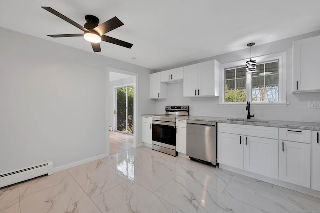 kitchen featuring white cabinetry, appliances with stainless steel finishes, marble finish floor, a sink, and baseboards