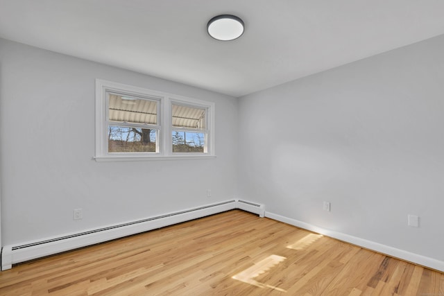 spare room featuring baseboards, wood finished floors, and baseboard heating