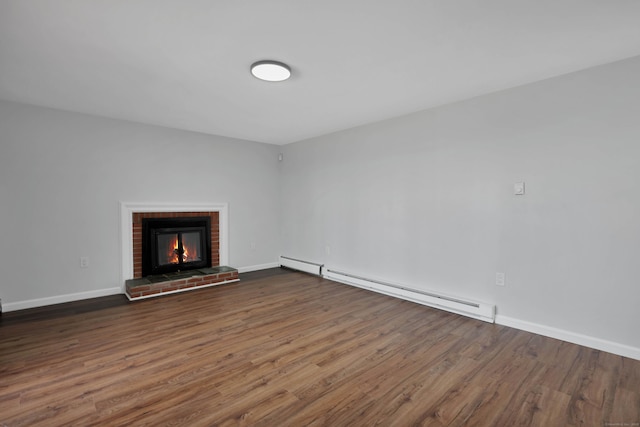 unfurnished living room featuring a baseboard radiator, a brick fireplace, wood finished floors, and baseboards