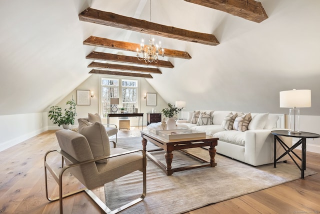 living area with a notable chandelier, hardwood / wood-style flooring, and lofted ceiling with beams