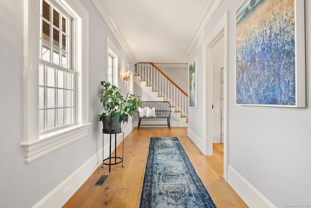 entrance foyer with stairway, ornamental molding, baseboards, hardwood / wood-style flooring, and visible vents