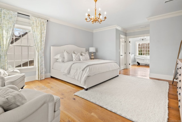 bedroom with wood finished floors, an inviting chandelier, and multiple windows