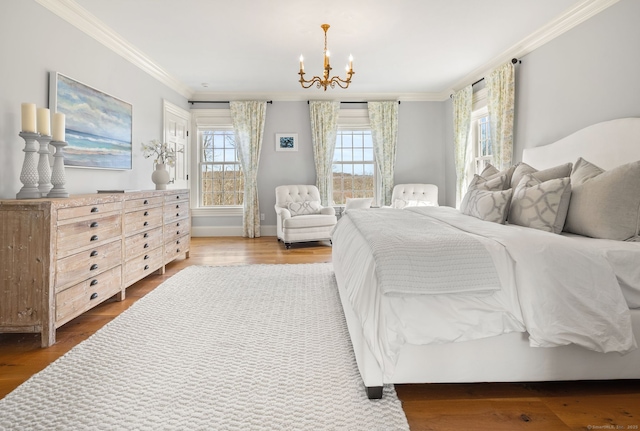 bedroom with baseboards, crown molding, wood finished floors, and a chandelier