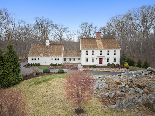 rear view of property with a lawn and a chimney