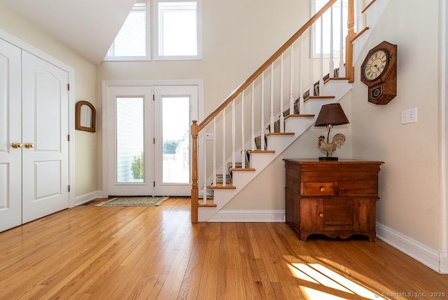 88 Sconset Ln, Guilford, CT 06437 - entryway featuring wood finished floors, high vaulted ceiling, baseboards, and stairway