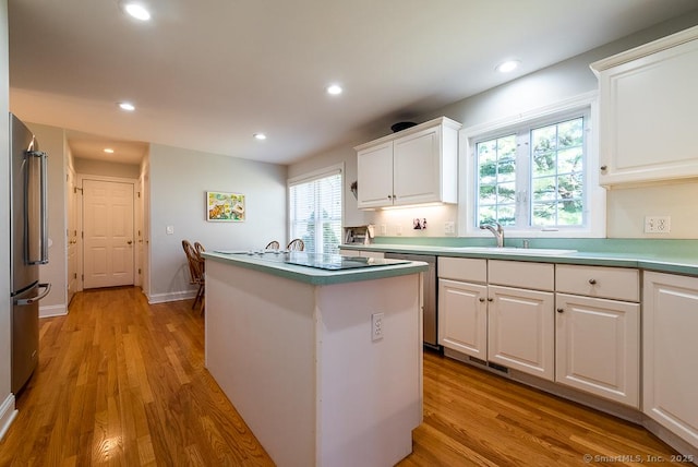 88 Sconset Ln, Guilford, CT 06437 - kitchen featuring appliances with stainless steel finishes, light wood finished floors, a sink, and white cabinets