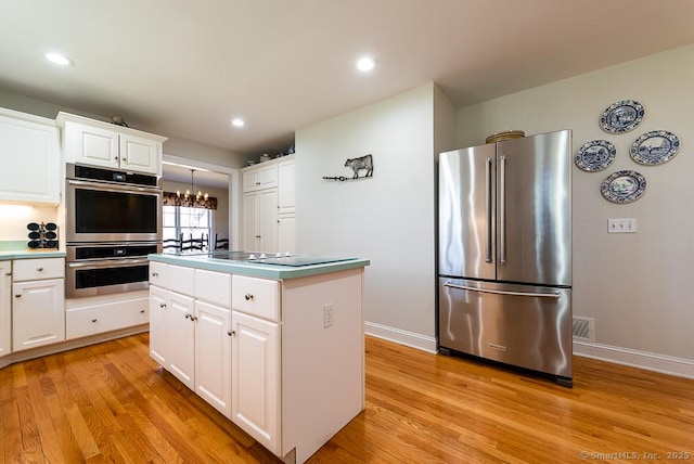 88 Sconset Ln, Guilford, CT 06437 - kitchen featuring white cabinets, baseboards, an inviting chandelier, appliances with stainless steel finishes, and light wood-style flooring