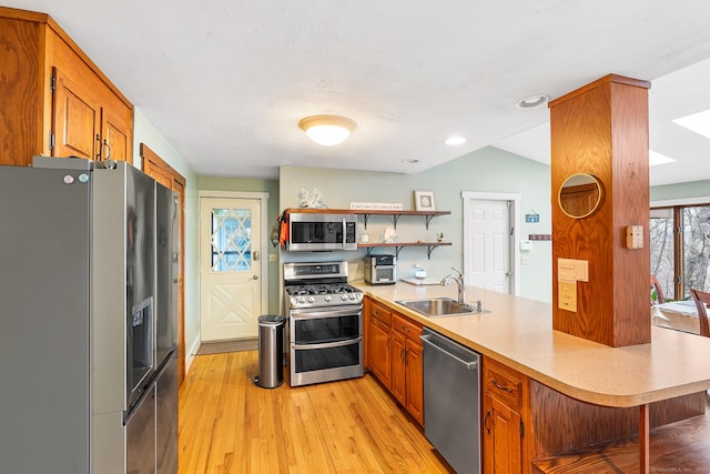 20 Sunrise Trl, East Lyme, CT 06333 - kitchen with appliances with stainless steel finishes, a sink, a peninsula, open shelves, and brown cabinetry