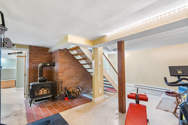 20 Sunrise Trl, East Lyme, CT 06333 - bedroom with baseboard heating, a wood stove, baseboards, a textured ceiling, and speckle patterned floor