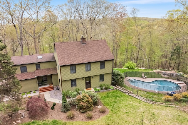 20 Sunrise Trl, East Lyme, CT 06333 - back of house featuring a chimney, roof with shingles, and a view of trees